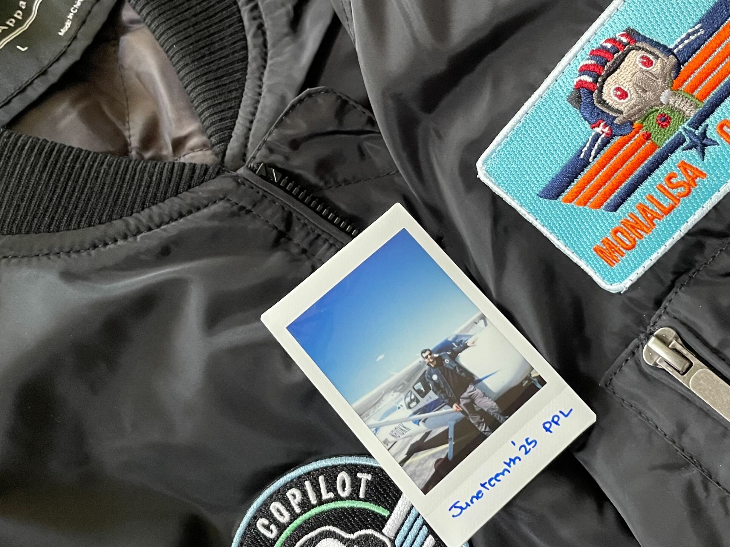 a polaroid photo of me against the single-engine plane I trained on, with a background of Copilot aviator jacket